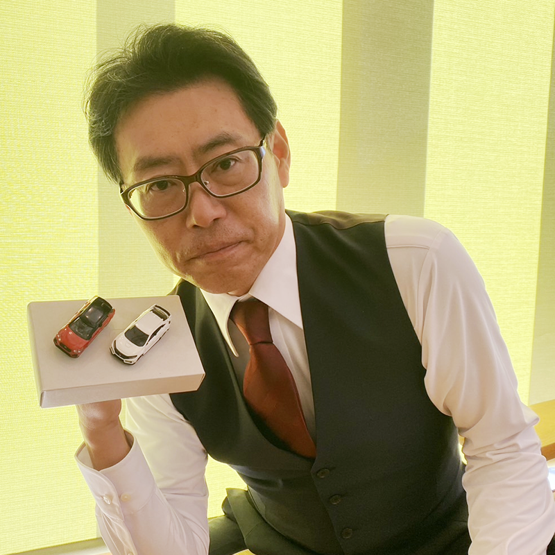 ミニカーを持つ田中社長の画像