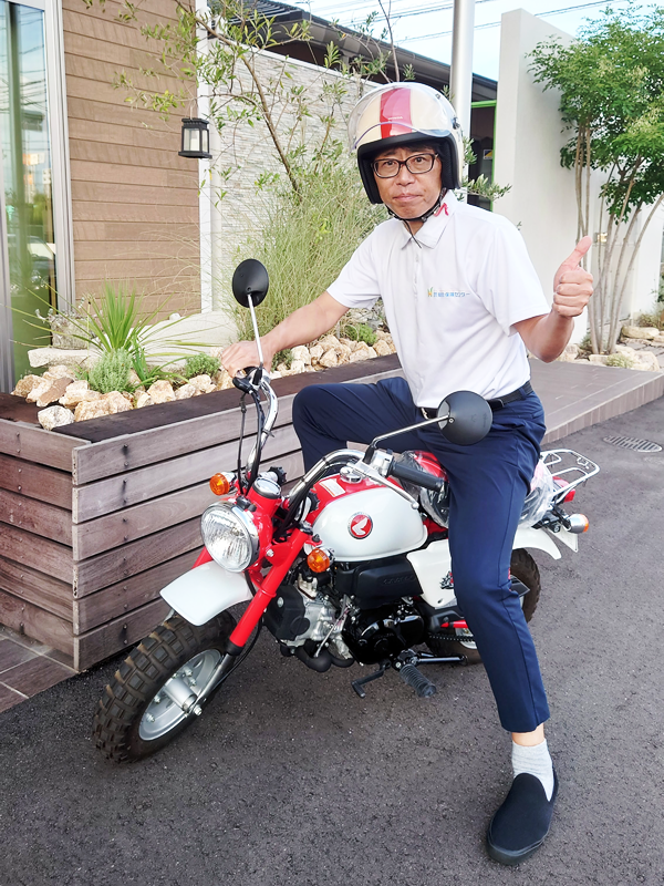 バイクに跨る田中社長の写真
